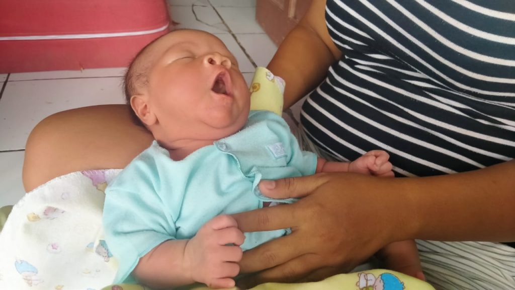 Galih Putrayono (12 hari) yang memiliki 12 jari tangan dan 12 jari kaki saat digendong ibunya di kediamannya di Desa Tugu Blok Gempol, Kecamatan Lelea, Kabupaten Indramayu. (Tomi Indra)