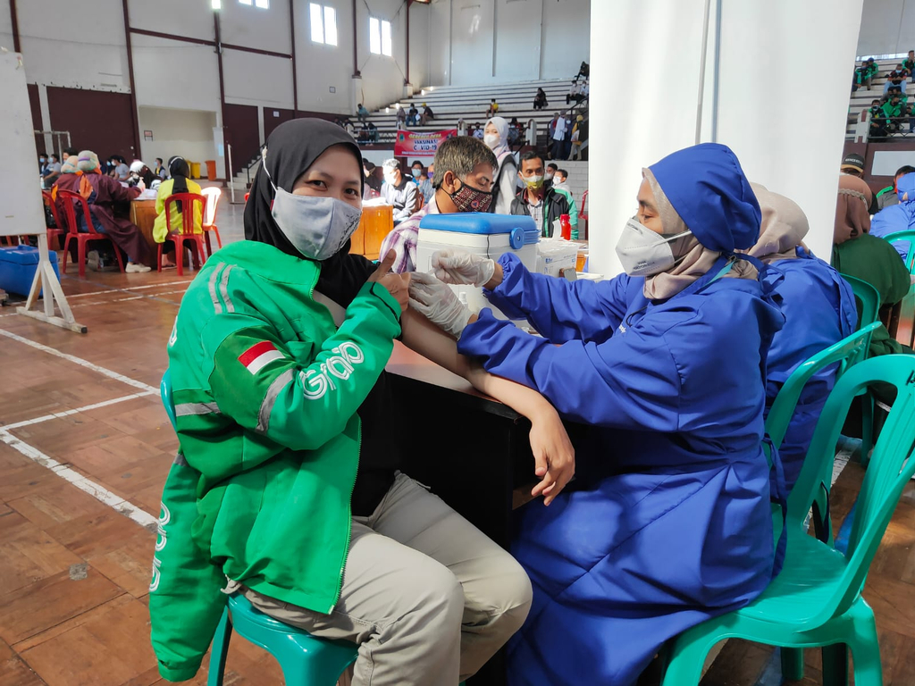 Seorang driver ojek online (ojol) menjalani program vaksinasi di GOR Ewangga, Kabupaten Kuningan, Rabu (11/8/2021). (Indramayujeh)