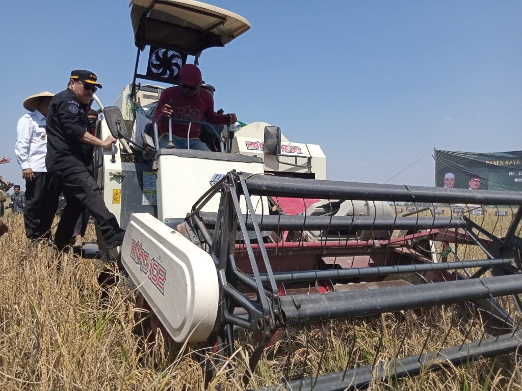 Caption : Irjen Kementan RI, Jan Samuel Maringka menaiki kendaraan mesin panen padi Combine Harvester pada kegiatan panen raya. Foto : Joni