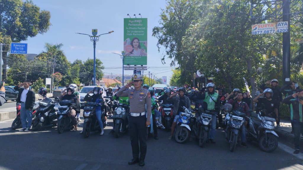 Caption : Pengendara sepeda motor dan mobil di perempatan lampu merah Gunung Sari Kota Cirebon saat memberikan penghormatan bendera merah putih. Foto : Joni